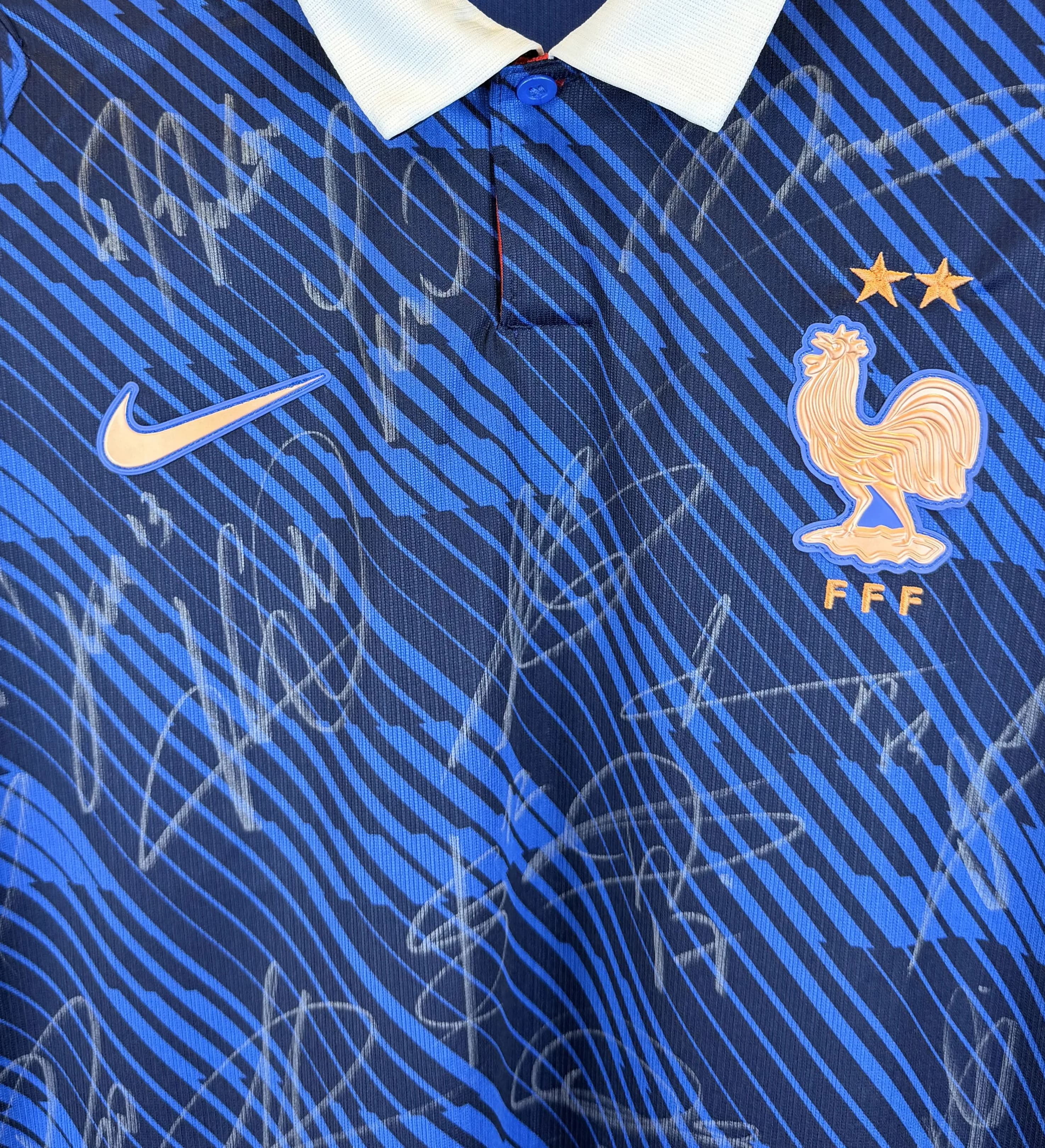 announcements/a7f5ae25-96ab-44da-99e7-aa3152476a24/1785345995041-Camisa-Franca-Copa-2026-Autografada-Elenco-Mbappe-+Credencial-+Copo-Detalhe.webp